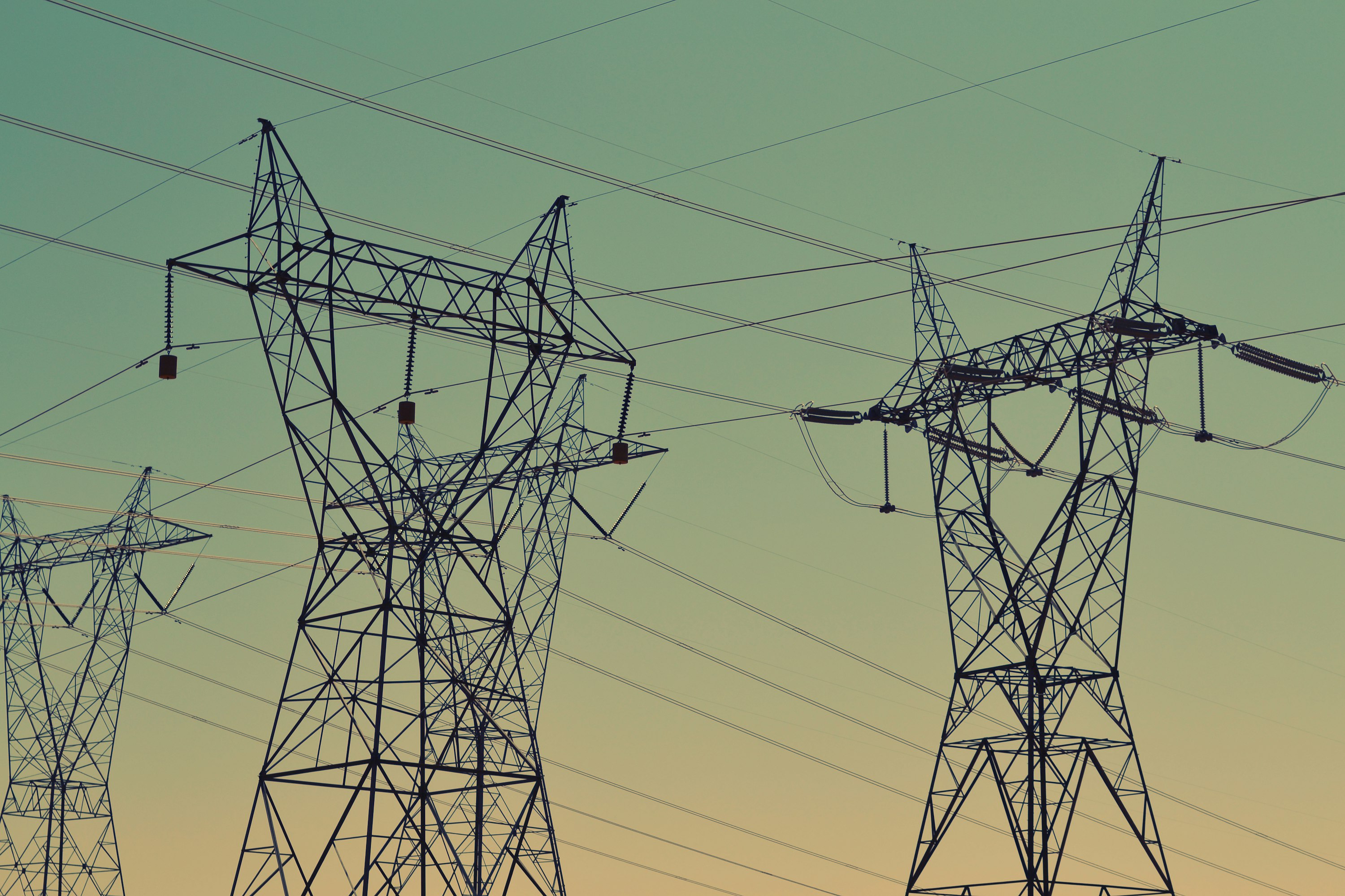 Silhouette of electrical transmission towers against a dusk sky