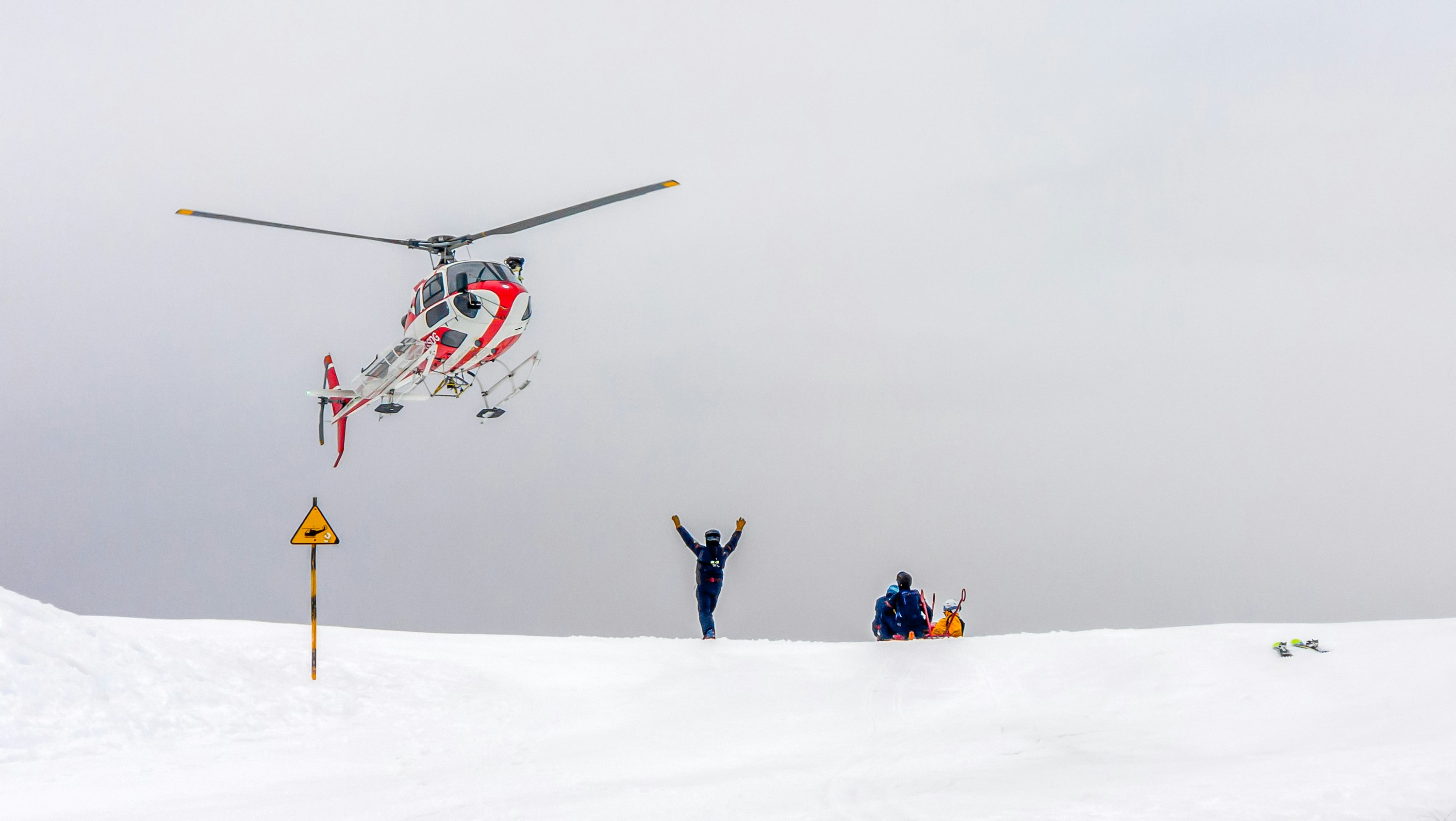 Helicopter conducting a mountain rescue operation in the snow